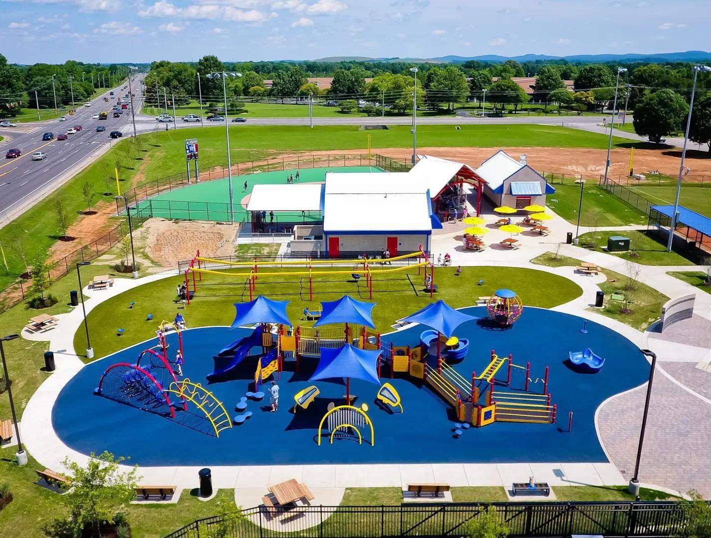 An aerial view of a park with a playground and umbrellas