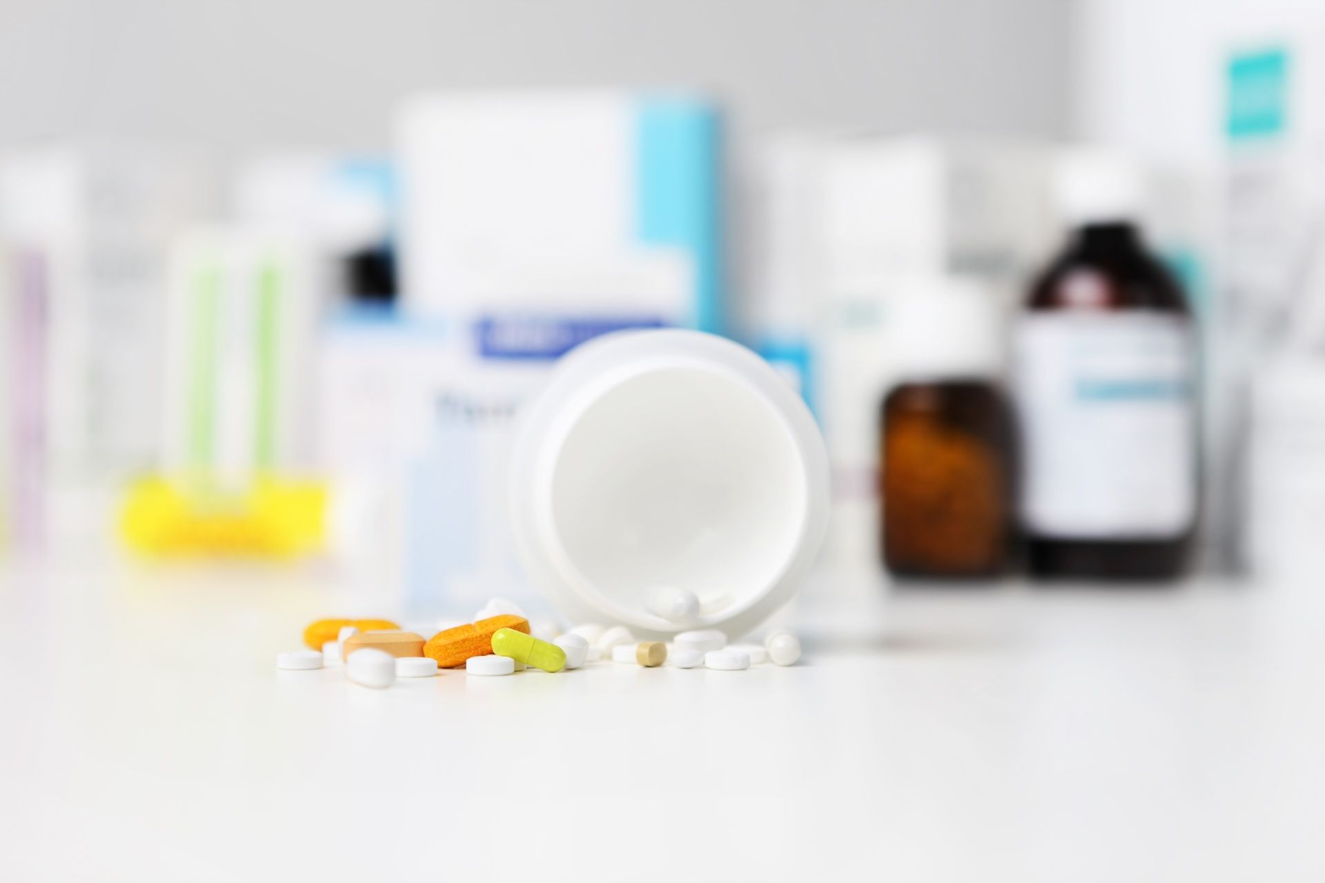 A bottle of pills is spilling out of it on a table.