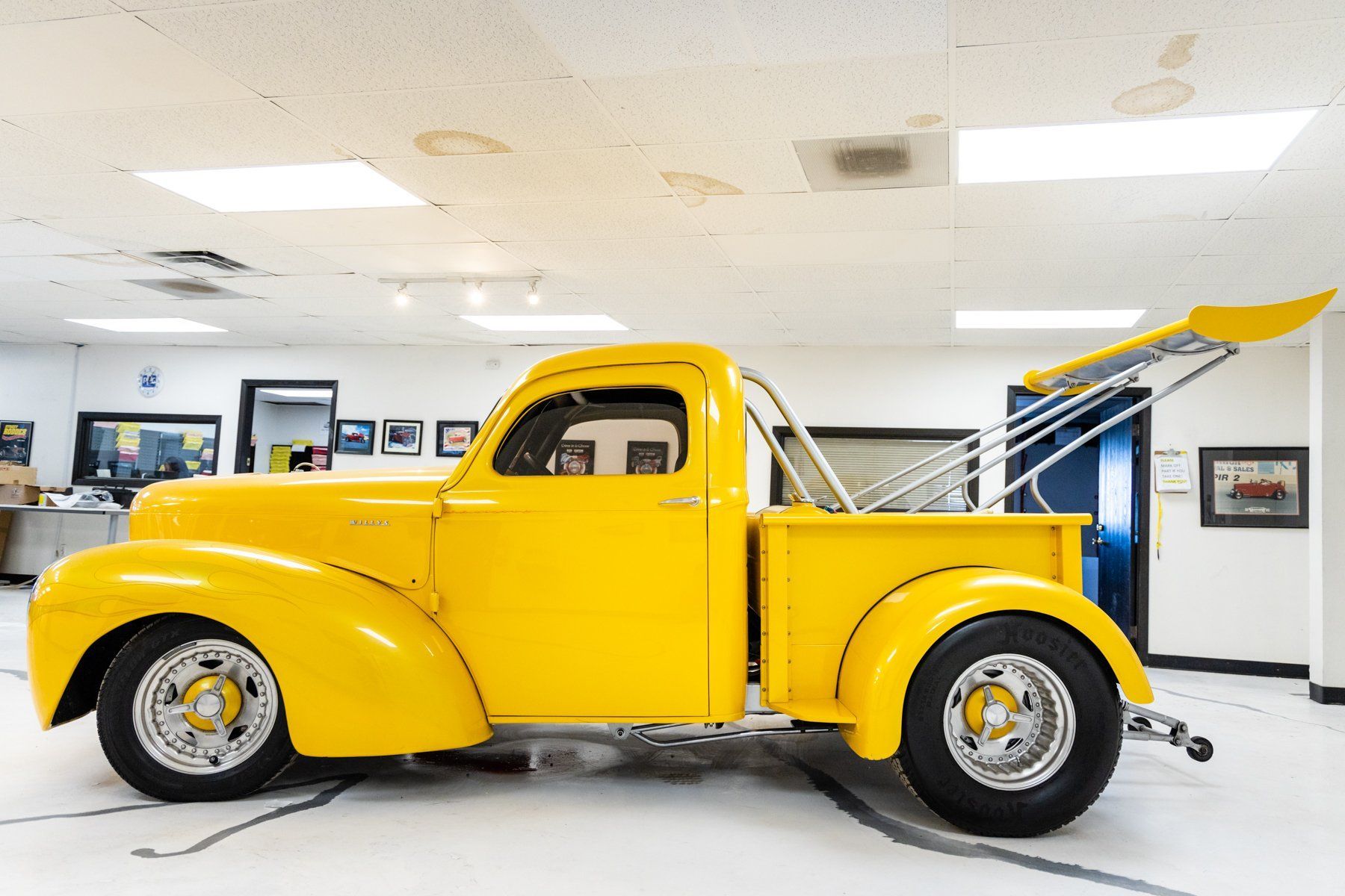 Yellow vintage tow truck in a brightly lit showroom.