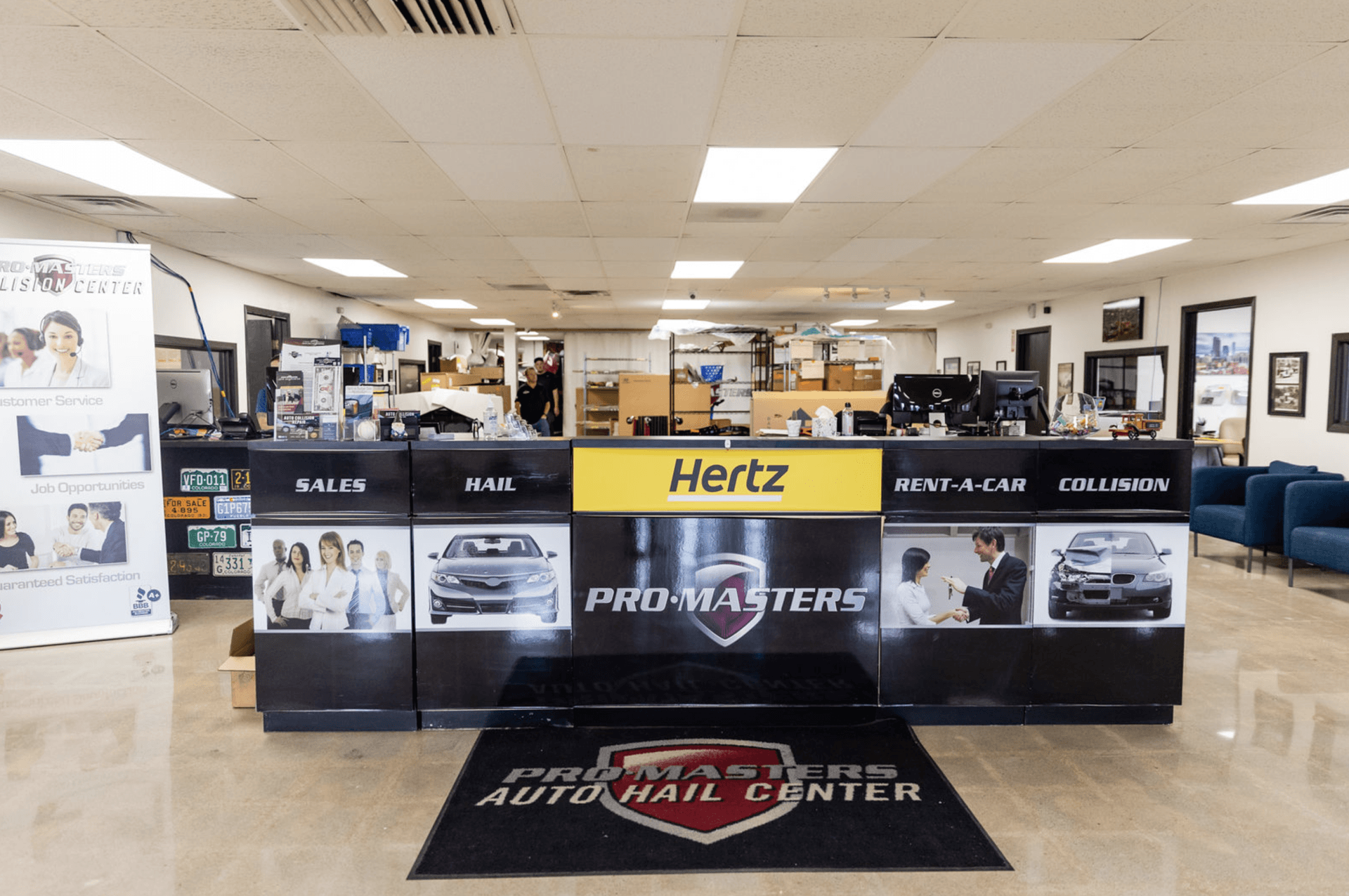 Reception area of a Pro Masters Auto Hail Center, with a Hertz counter.