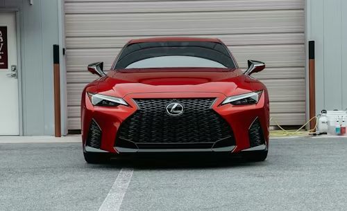Red Lexus sports car parked in front of a gray garage door