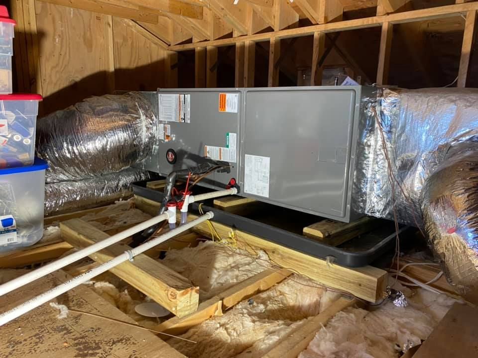 An air conditioner is sitting in the attic of a house under construction.