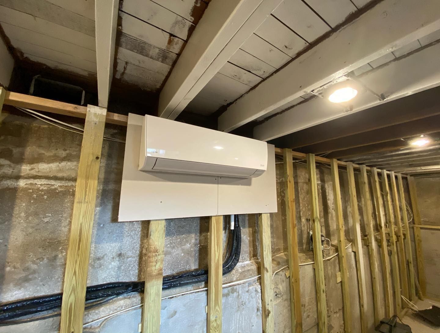 A white box is hanging from the ceiling in a room with wooden beams.