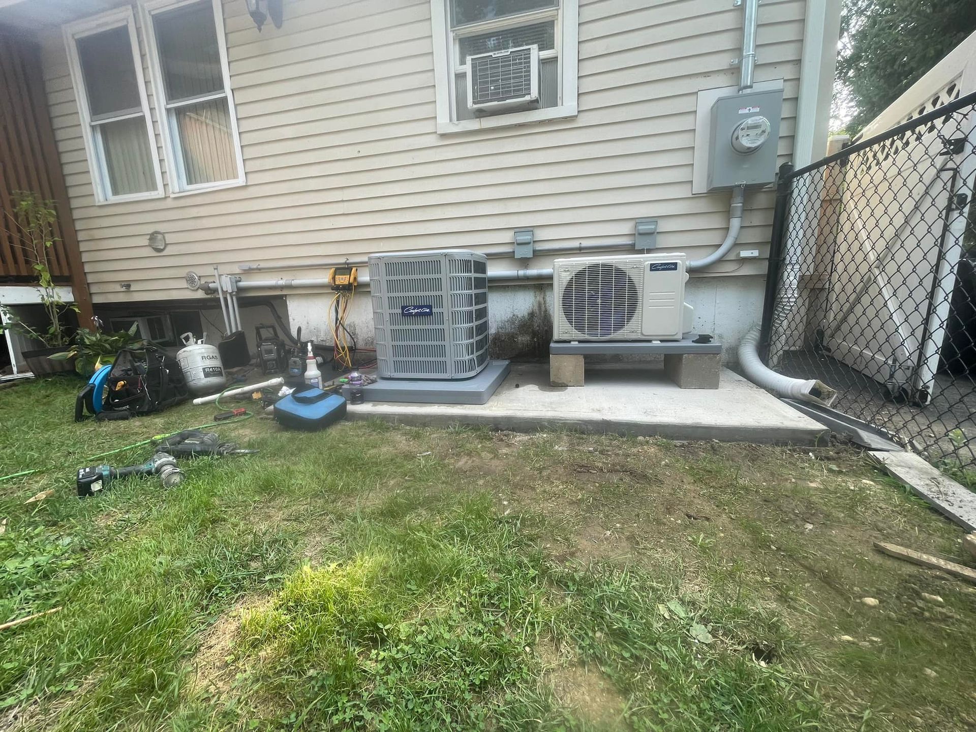 A house with two air conditioners on the side of it.