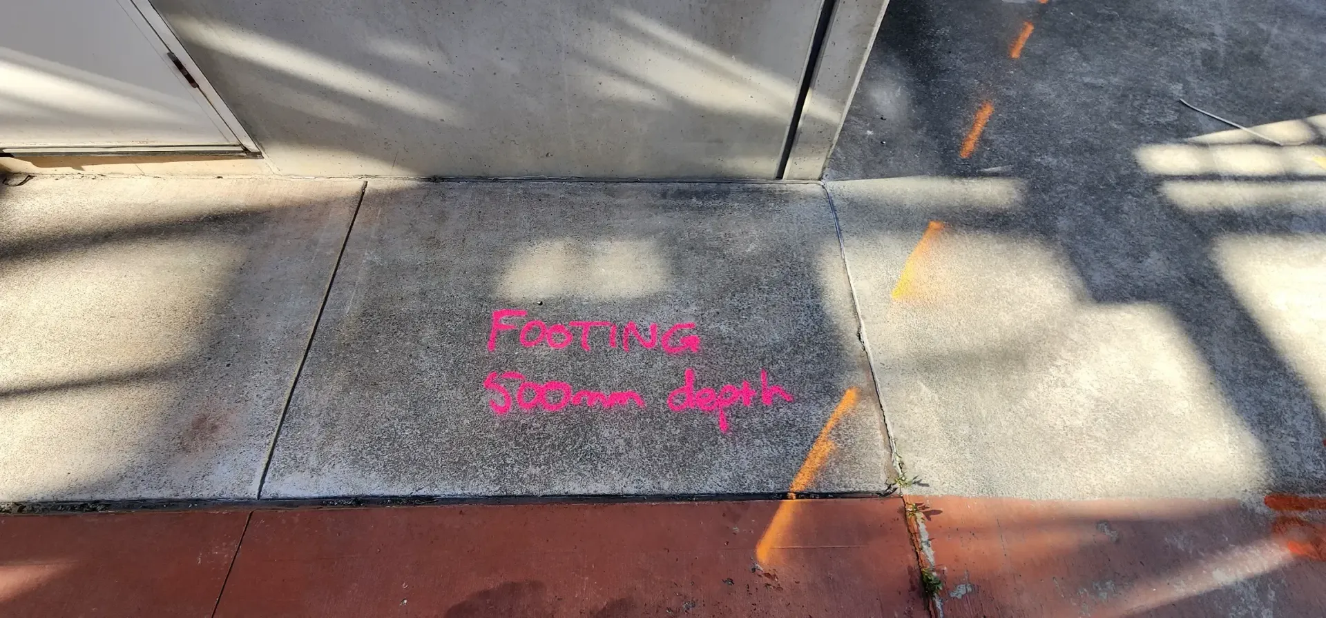 Pink text on pavement reads: 
