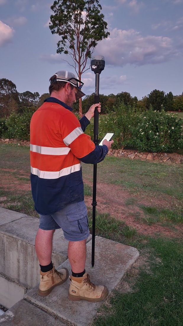 Man in Work Clothes Uses GPS Device, Outdoors — Found It Down Under in Gympie, QLD