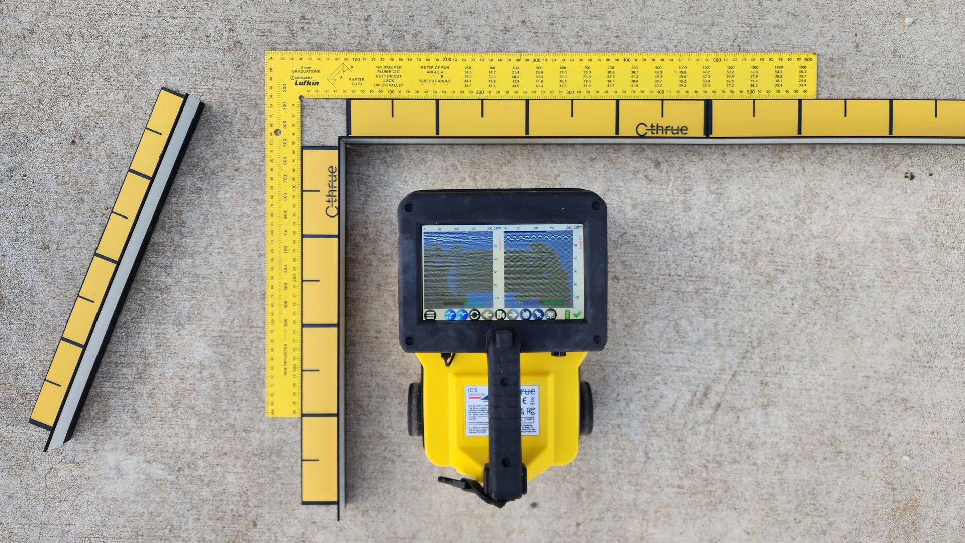 Yellow surveying equipment with a screen, measuring tools, and a concrete surface — Found It Down Under in Gympie, QLD