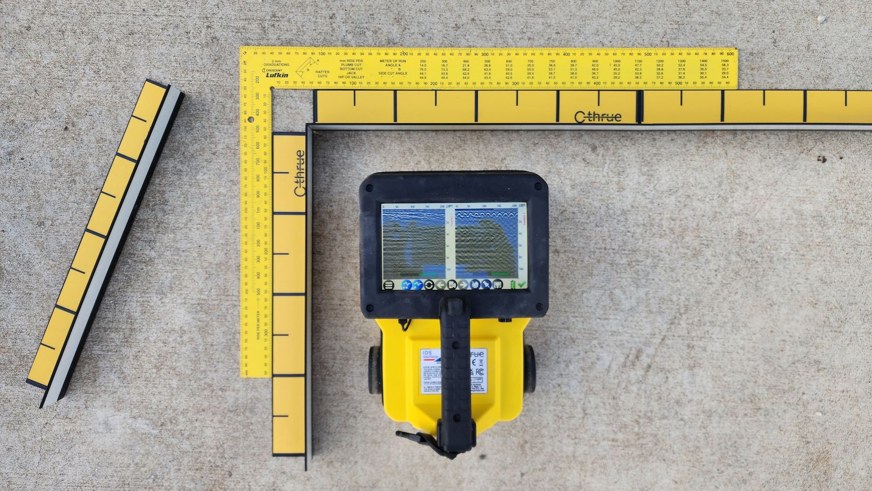 Yellow Surveying Equipment With a Screen, Measuring Tools, and a Concrete Surface — Found It Down Under in Howard, QLD