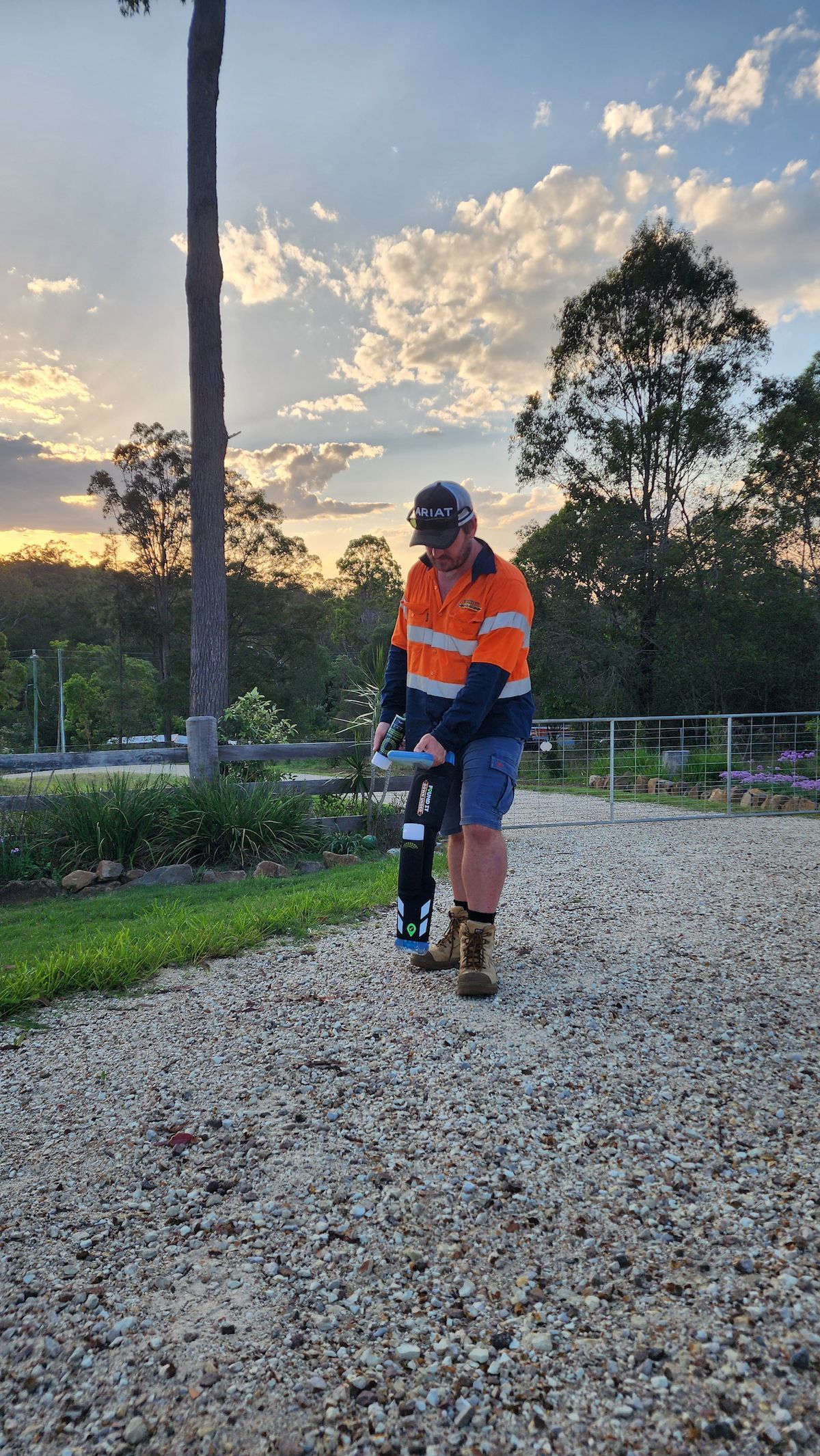 Man Compacts Gravel With a Machine, Wearing Work Clothes, Under a Sunset Sky — Found It Down Under in Gympie, QLD