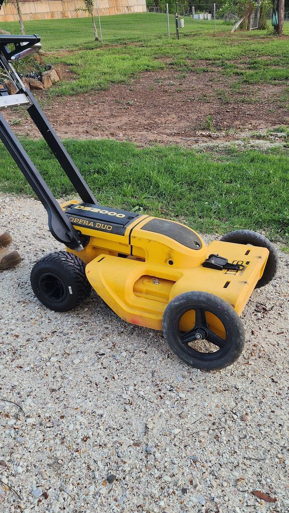 Yellow and Black Cordless Lawn Mower on a Gravel Path — Found It Down Under in Cooroy, QLD