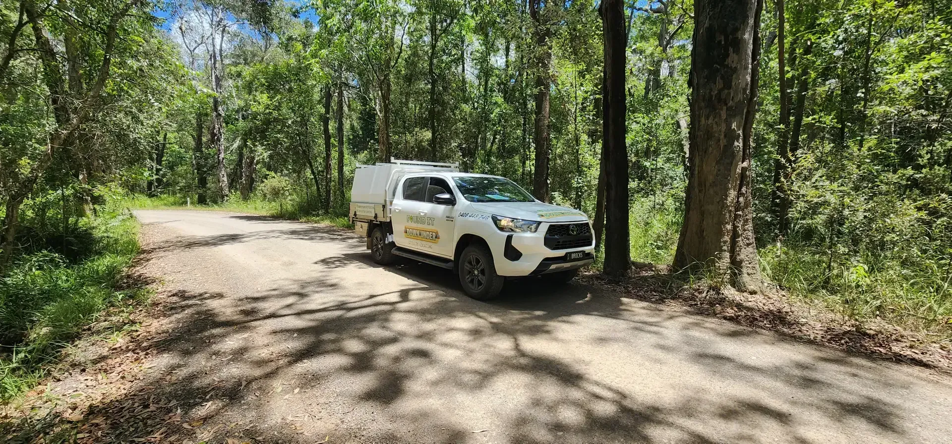 White truck parked on a dirt road in a forest, trees surround the vehicle. — Found It Down Under in Gympie, QLD