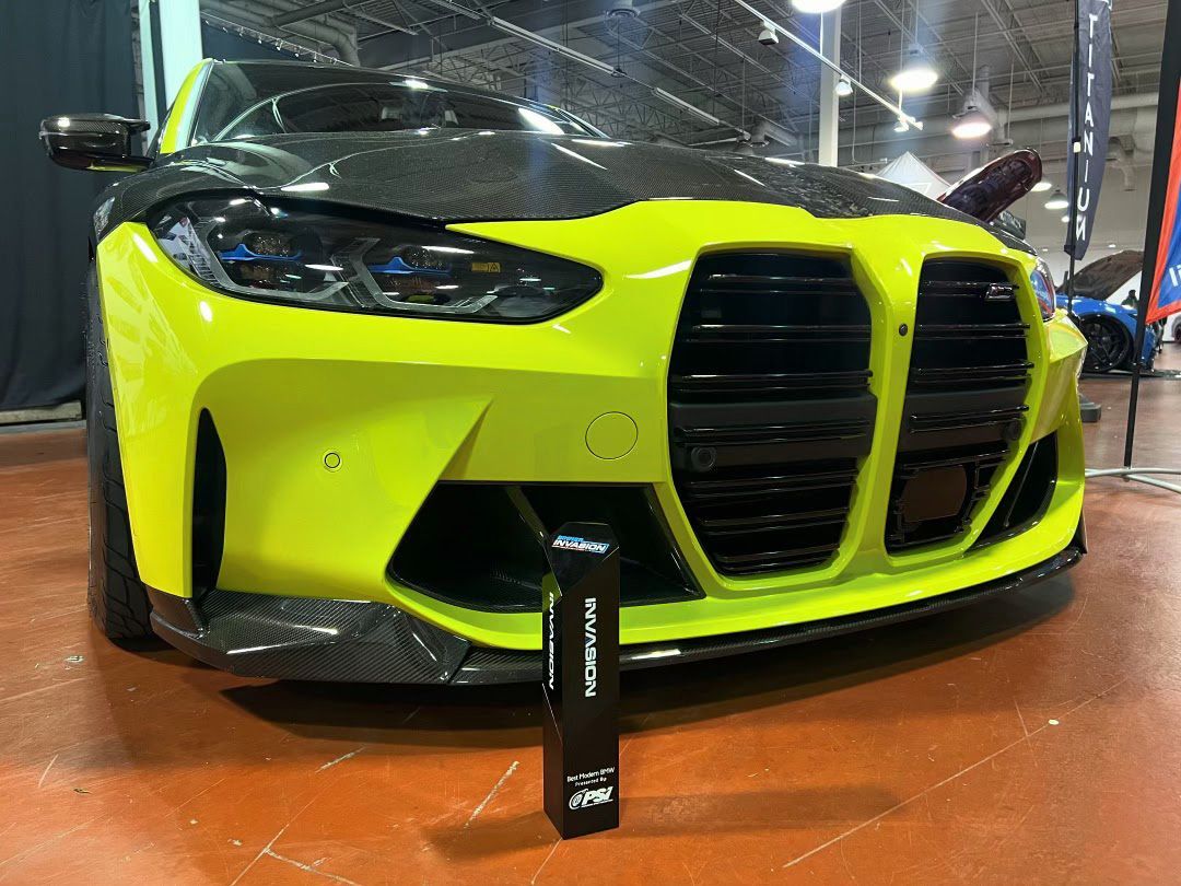 Lime green and black BMW sports car on display indoors.| Midnite Tuning