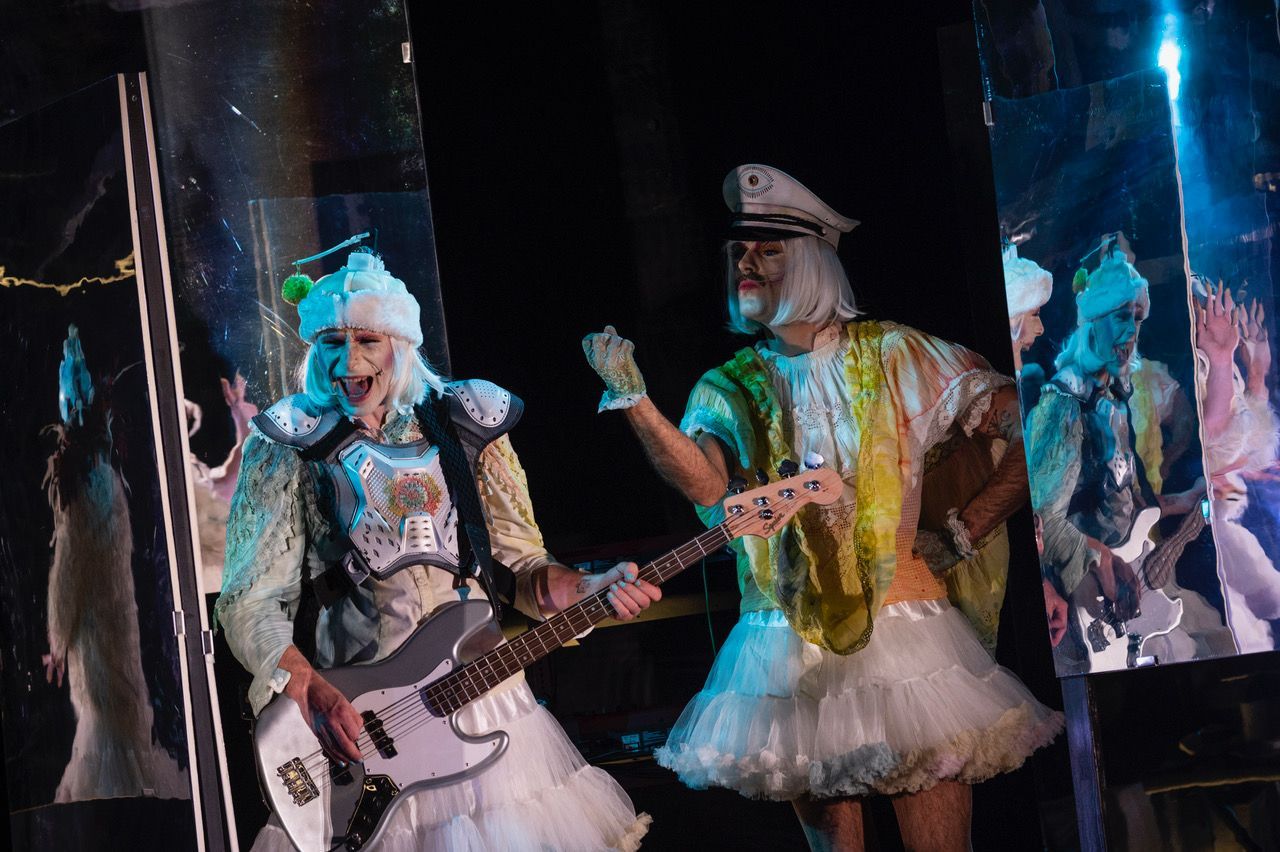 Eine Frau steht vor einem Stapel bunter Handtücher