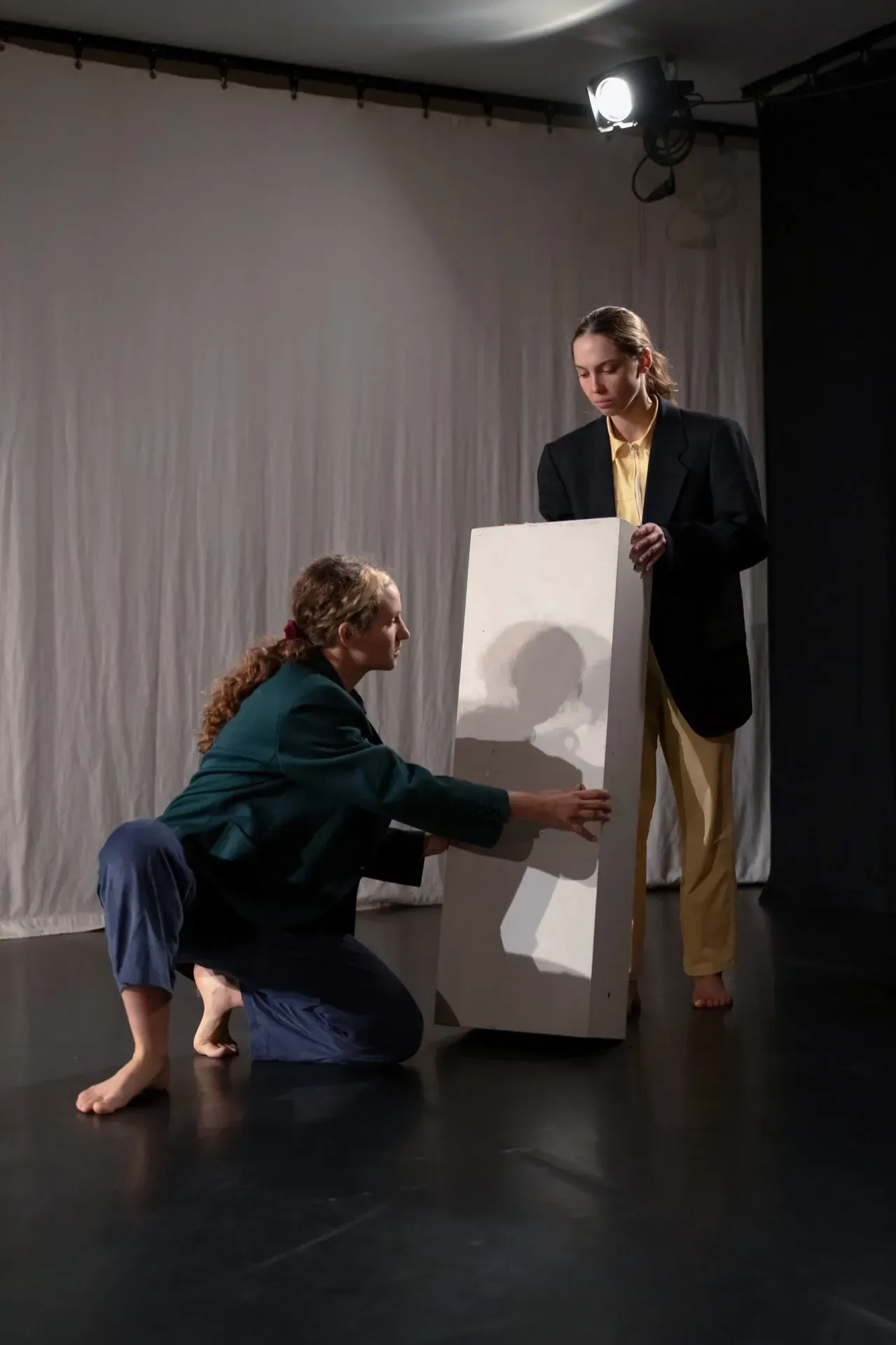 Eine Frau kniet neben einem Mann und hält ein Stück Papier in der Hand.