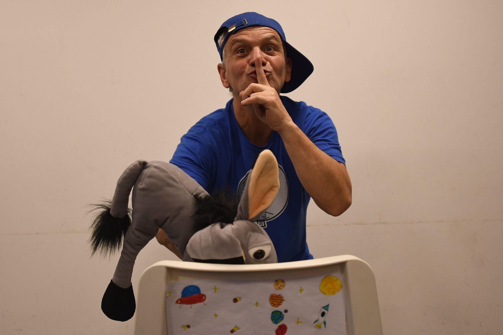 Ein Mann in einem blauen Hemd hält einen ausgestopften Esel