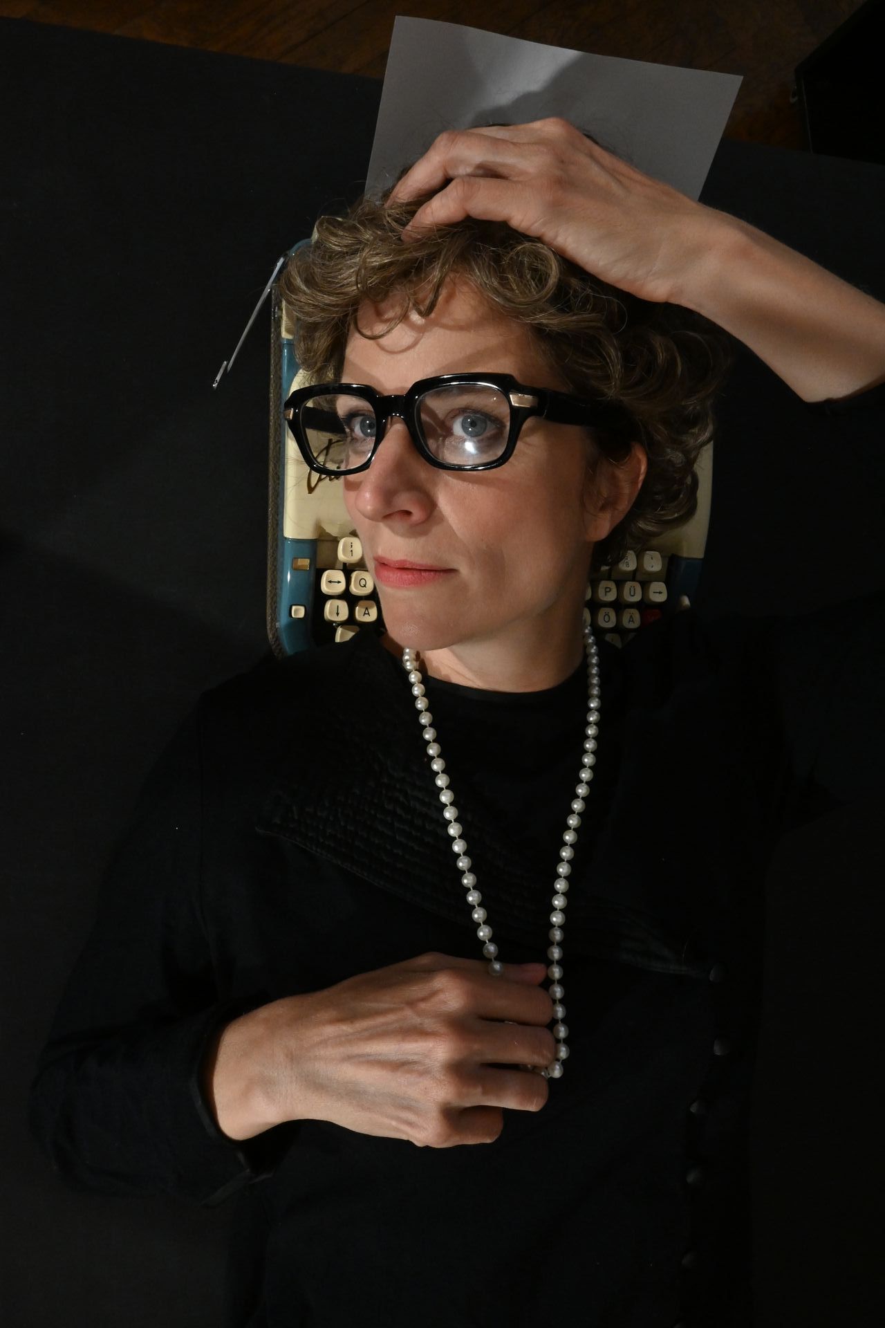 Eine Frau mit Brille und Perlenkette