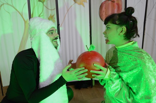 Ein Mann und eine Frau stehen nebeneinander und halten einen Apfel in der Hand.