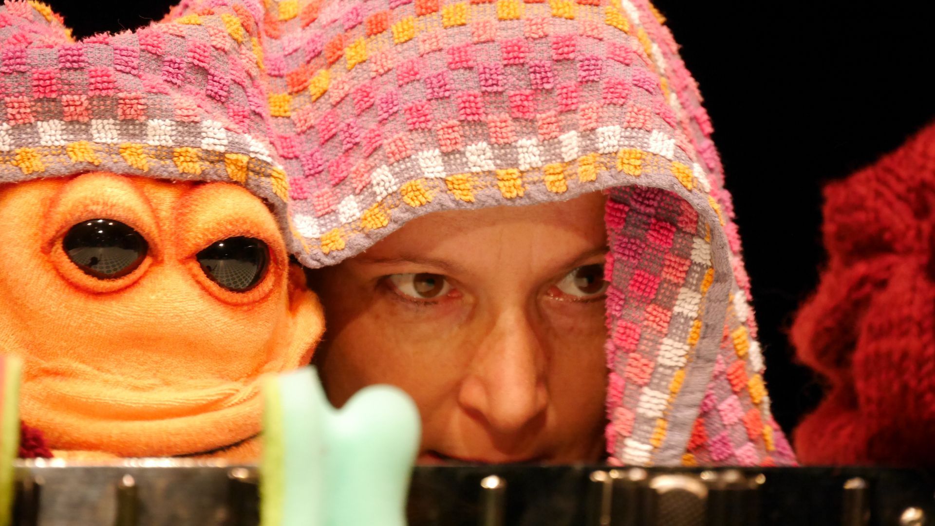 Eine Frau mit einem rosa Handtuch auf dem Kopf schaut auf zwei Stofftiere