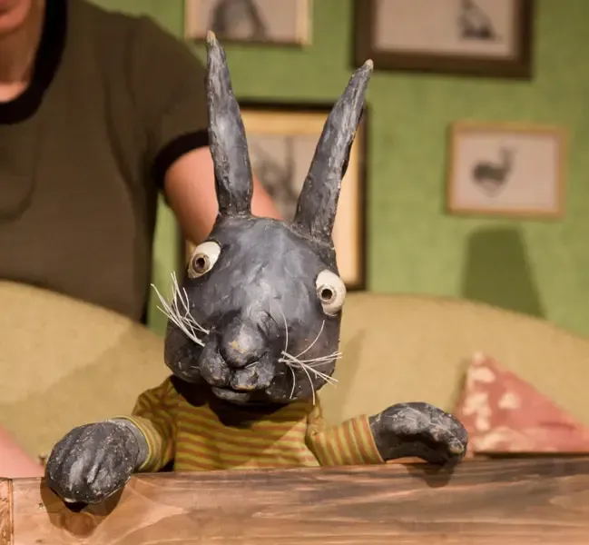 Eine Person hält eine Puppe eines schwarzen Kaninchens