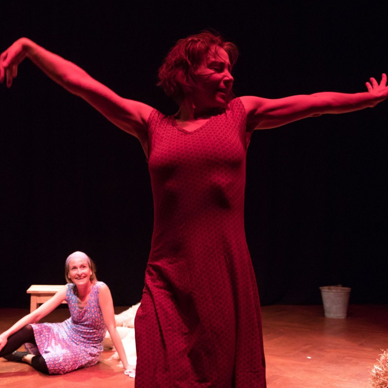 Eine Frau in einem roten Kleid tanzt auf einer Bühne