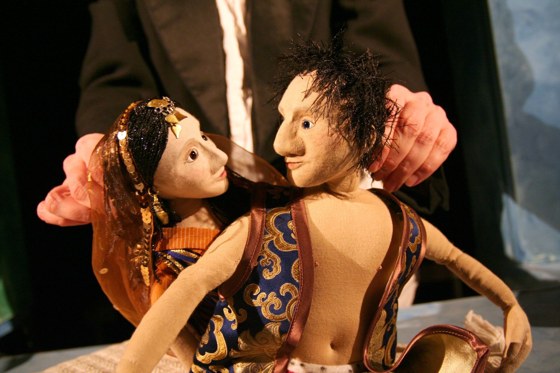 Eine Frau spielt mit einer Puppe auf einer Bühne