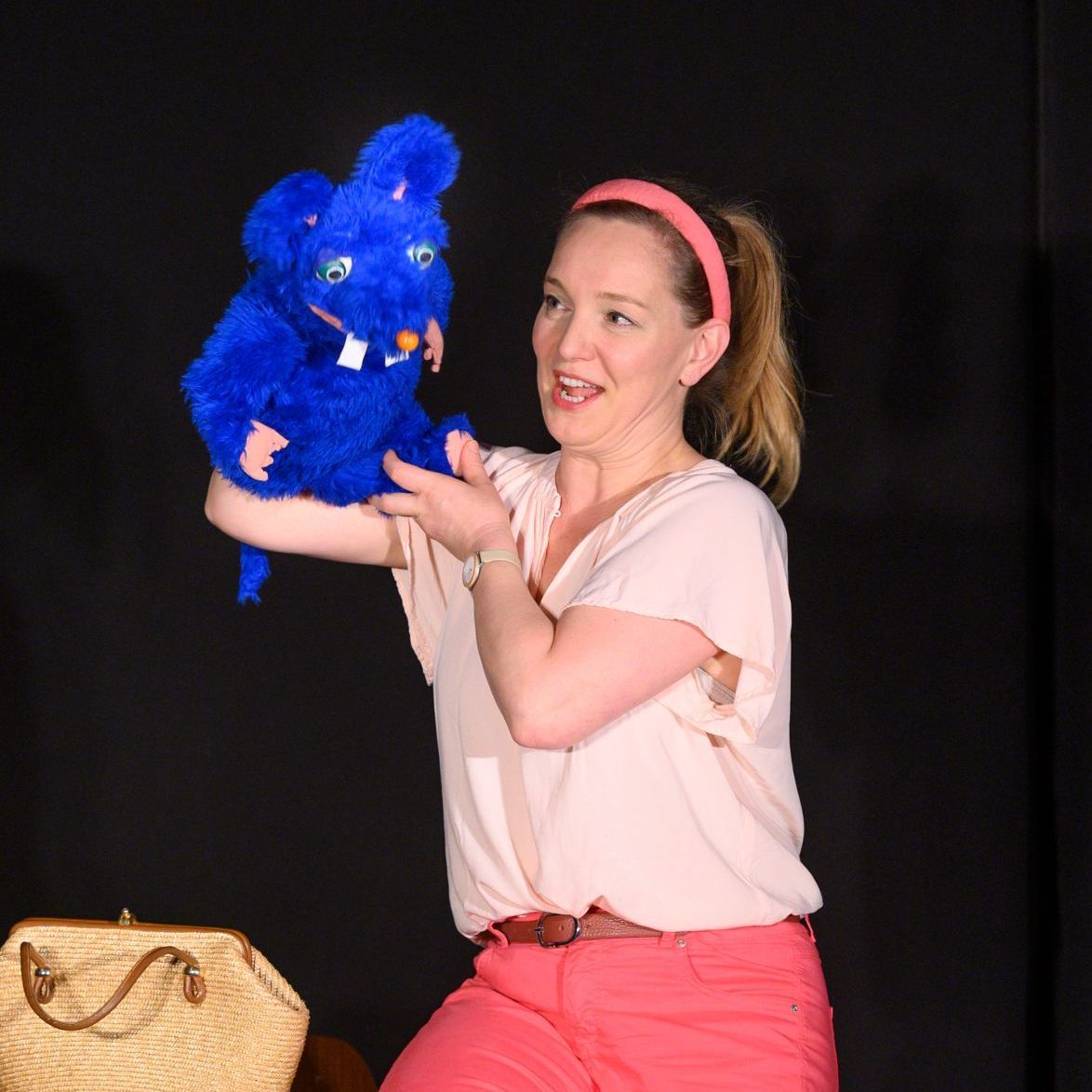 Eine Frau hält ein blaues Stofftier in ihren Händen