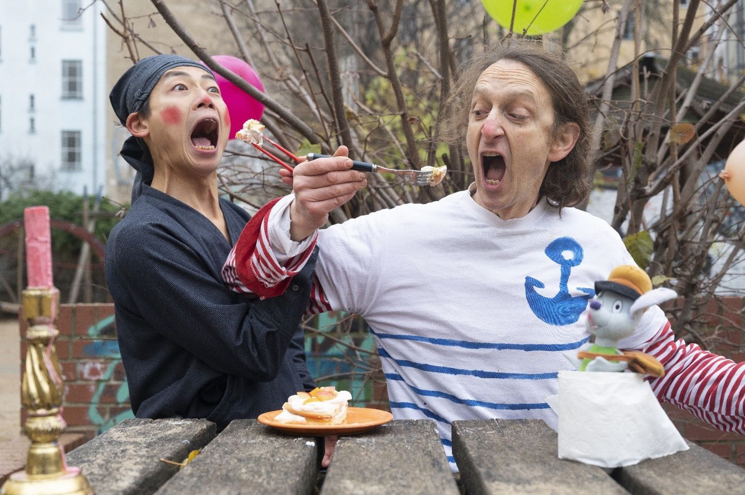 Ein lila und orangefarbener Fisch hängen an einer Kette