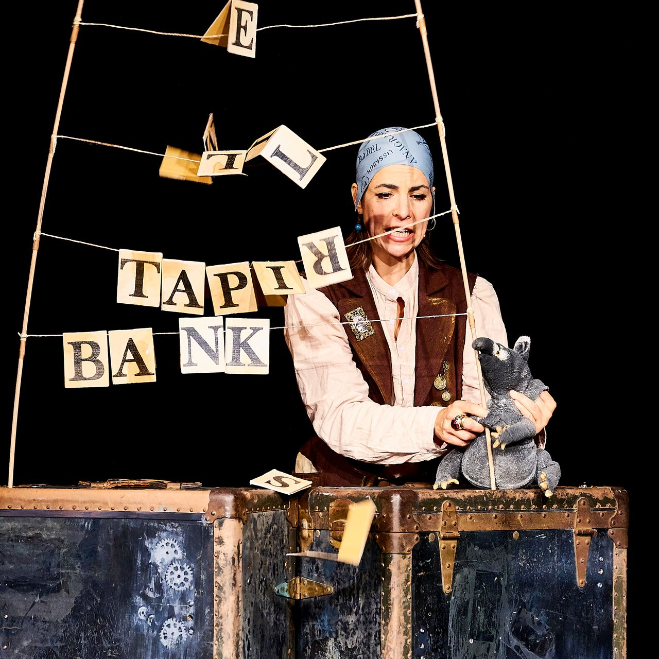 Ein ausgestopfter Igel und ein ausgestopfter Hase stehen vor einer Wanduhr