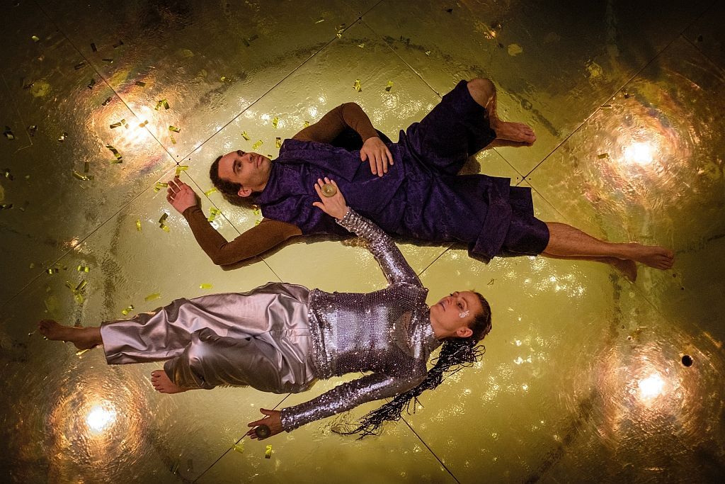 Eine Frau spielt mit einer Puppe auf einer Bühne