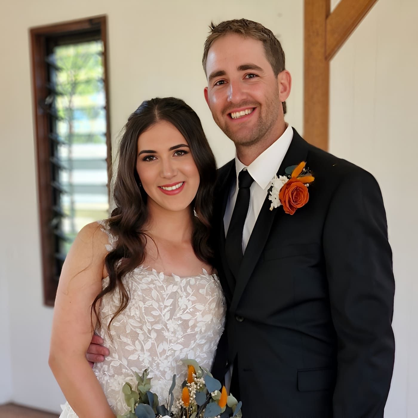 A Bride And Groom Pose For A Picture In Front Of A Window — Lynda Ross Marriage Celebrant In Alice River, QLD