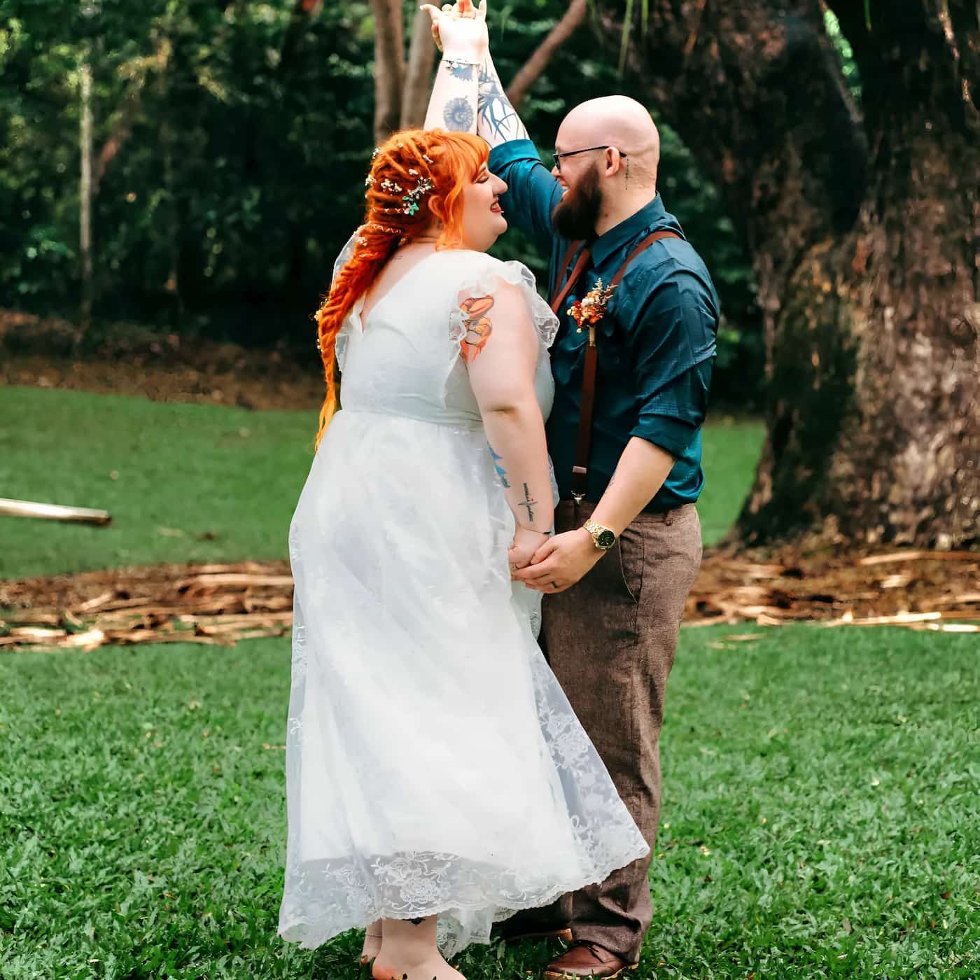 A Bride And Groom Are Dancing In The Grass — Lynda Ross Marriage Celebrant In Townsville, QLD