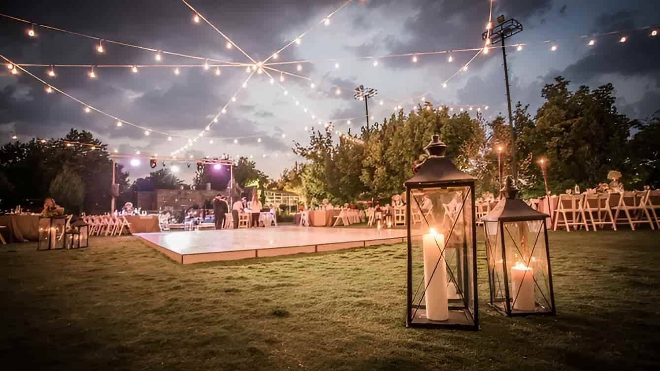 A Wedding Reception With A Dance Floor And Lanterns In The Grass — Lynda Ross Marriage Celebrant In Alice River, QLD