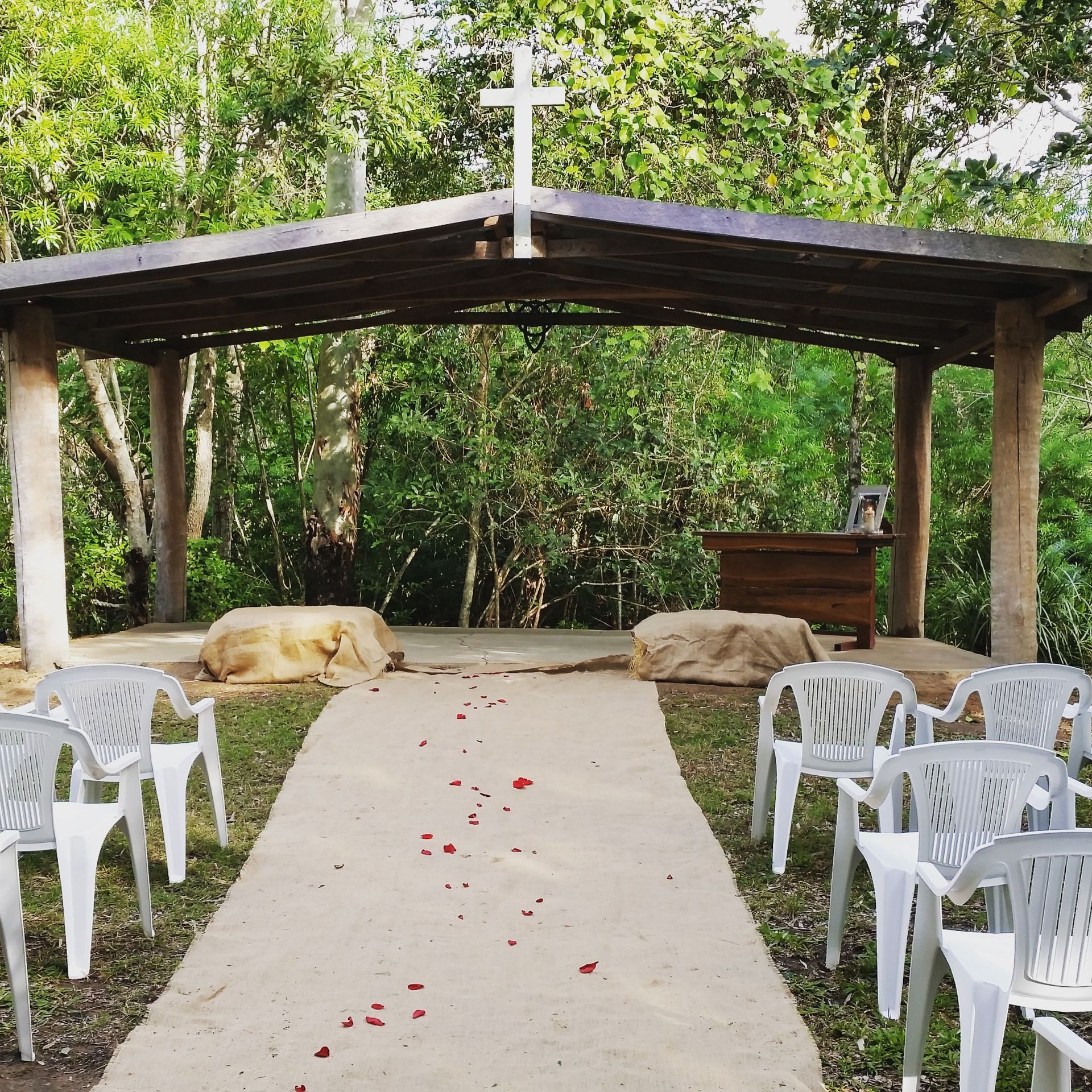 Hervey Range Wedding Outdoor Chapel  with chairs & rose petals — Lynda Ross Marriage Celebrant In Hervey Range, QLD