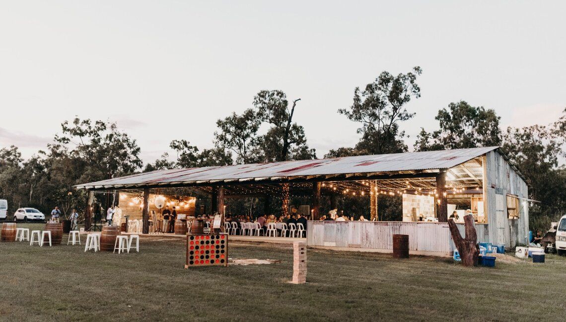 A Large White Building With A Tin Roof Is Sitting In The Middle Of A Grassy Field — Lynda Ross Marriage Celebrant In Hughenden, QLD