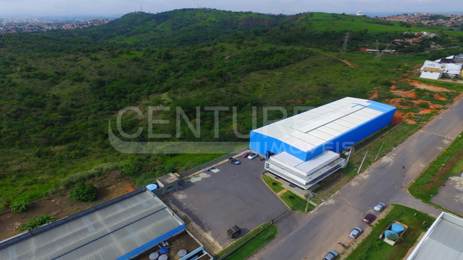 Uma vista aérea de uma área industrial com um grande edifício azul no meio.