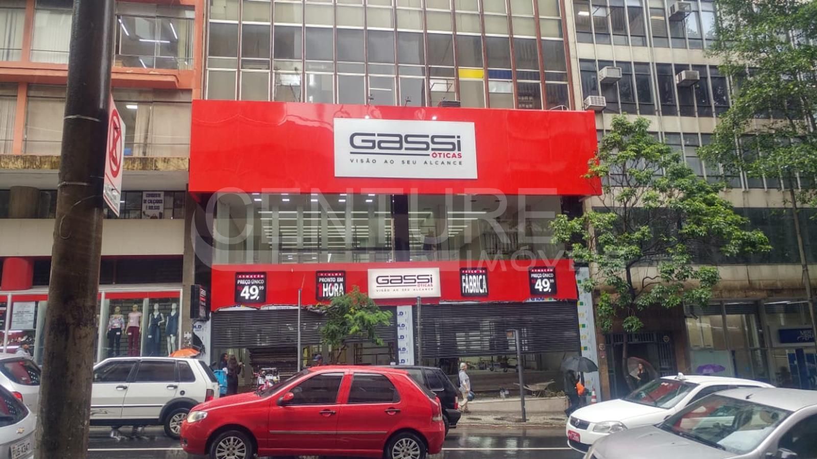 Um carro vermelho está estacionado em frente a uma loja de artigos esportivos