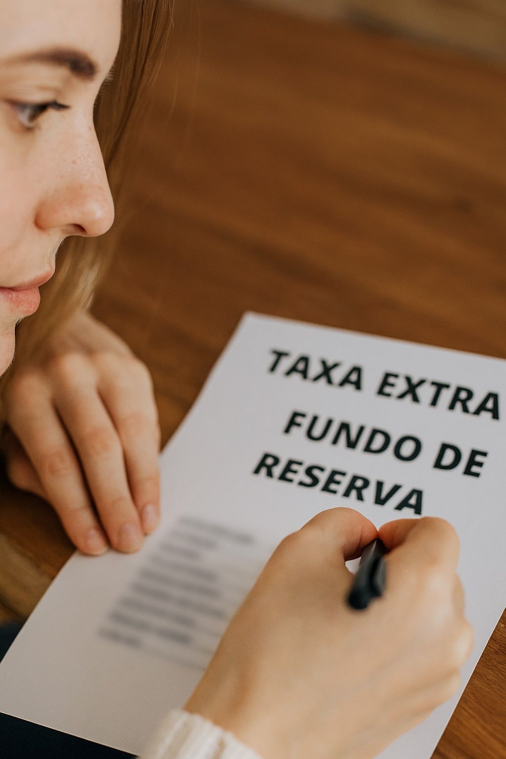 Uma mulher está escrevendo em um pedaço de papel que diz taxa extra fundo de reserva
