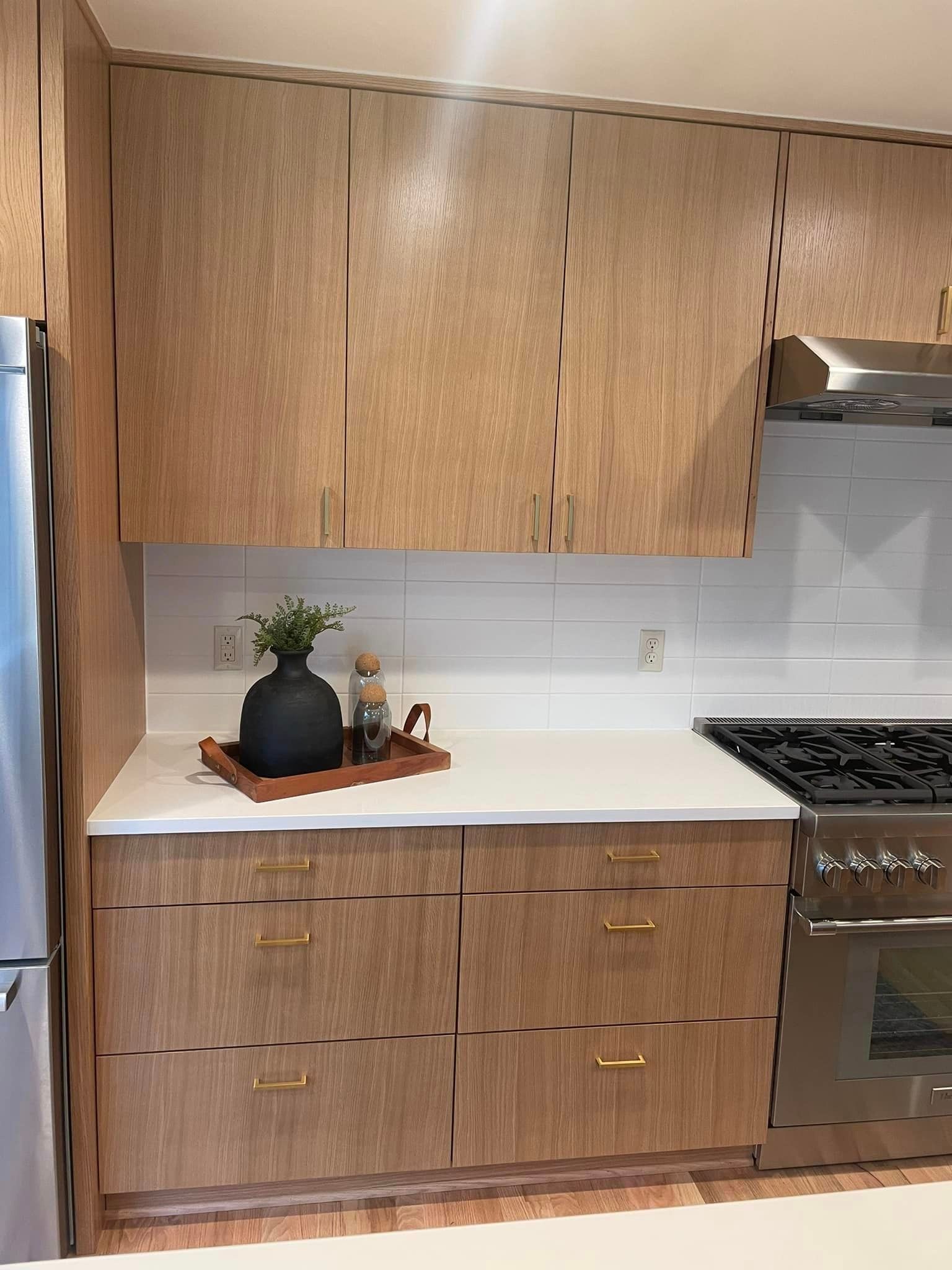 A kitchen with white cabinets and a stainless steel refrigerator