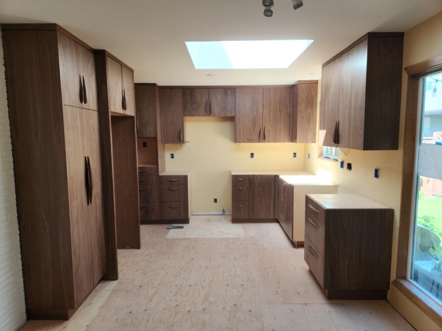 A kitchen with wooden cabinets and a skylight