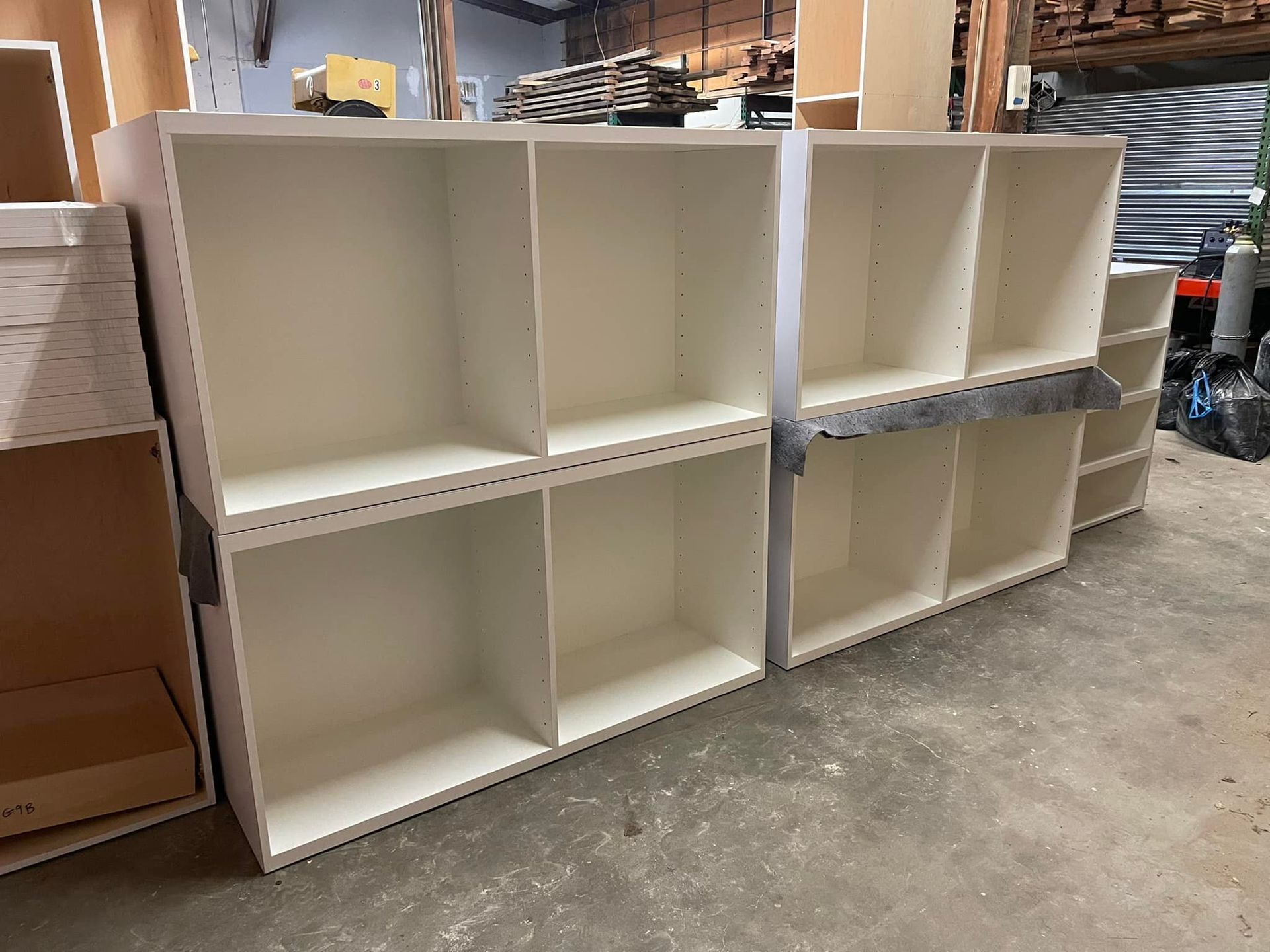 A row of white shelves sitting on top of a concrete floor in a warehouse.