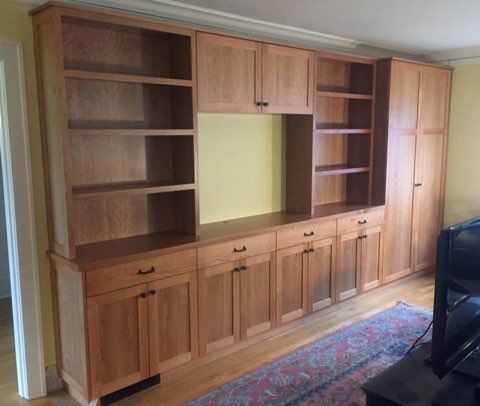 A bathroom vanity with wooden cabinets and drawers and a mirror.
