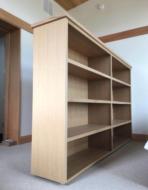 A wooden bookshelf is sitting in a room next to a door