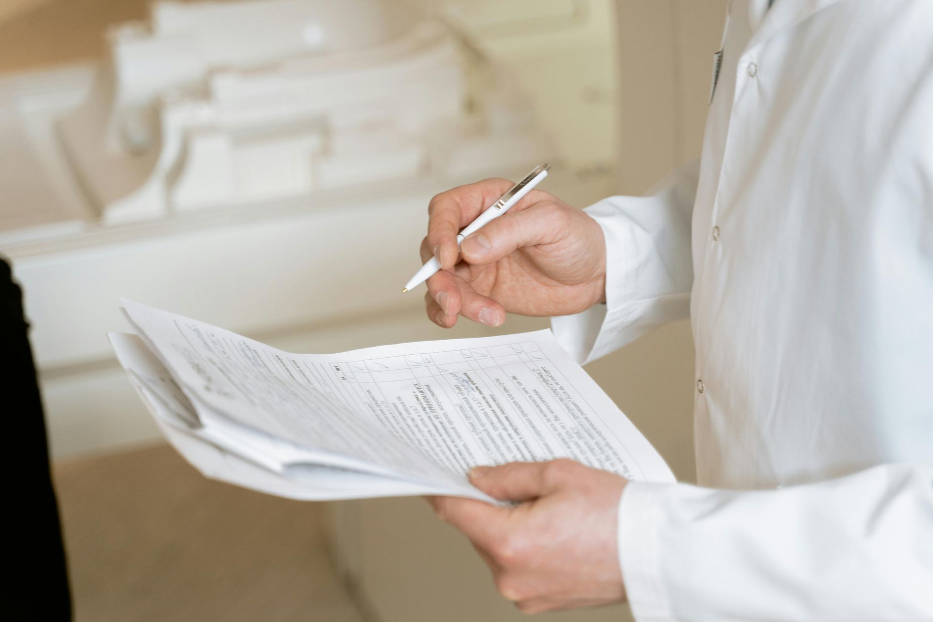 A doctor is writing on a piece of paper with a pen.