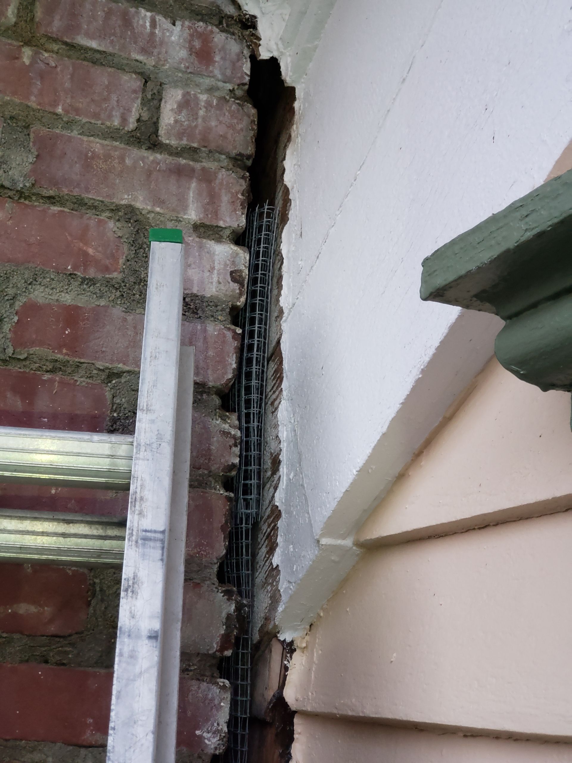 A ladder is leaning against a brick wall.