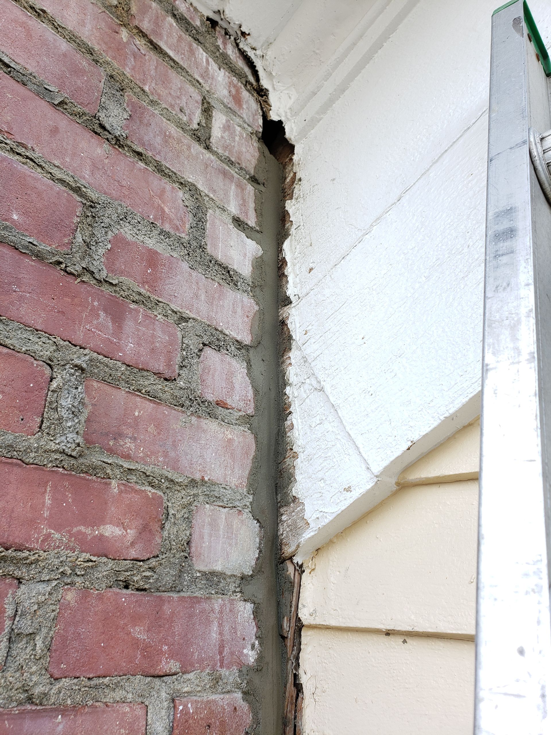 A brick wall with a ladder next to it