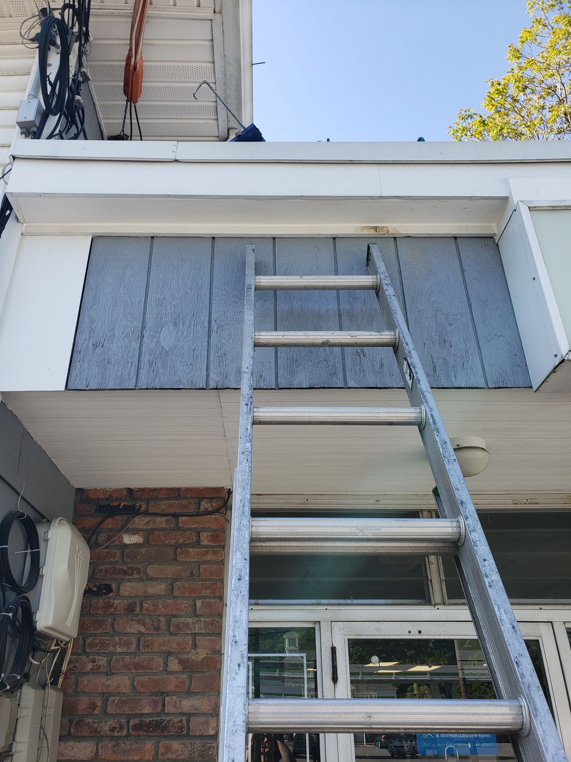 A ladder is sitting on top of a brick building.