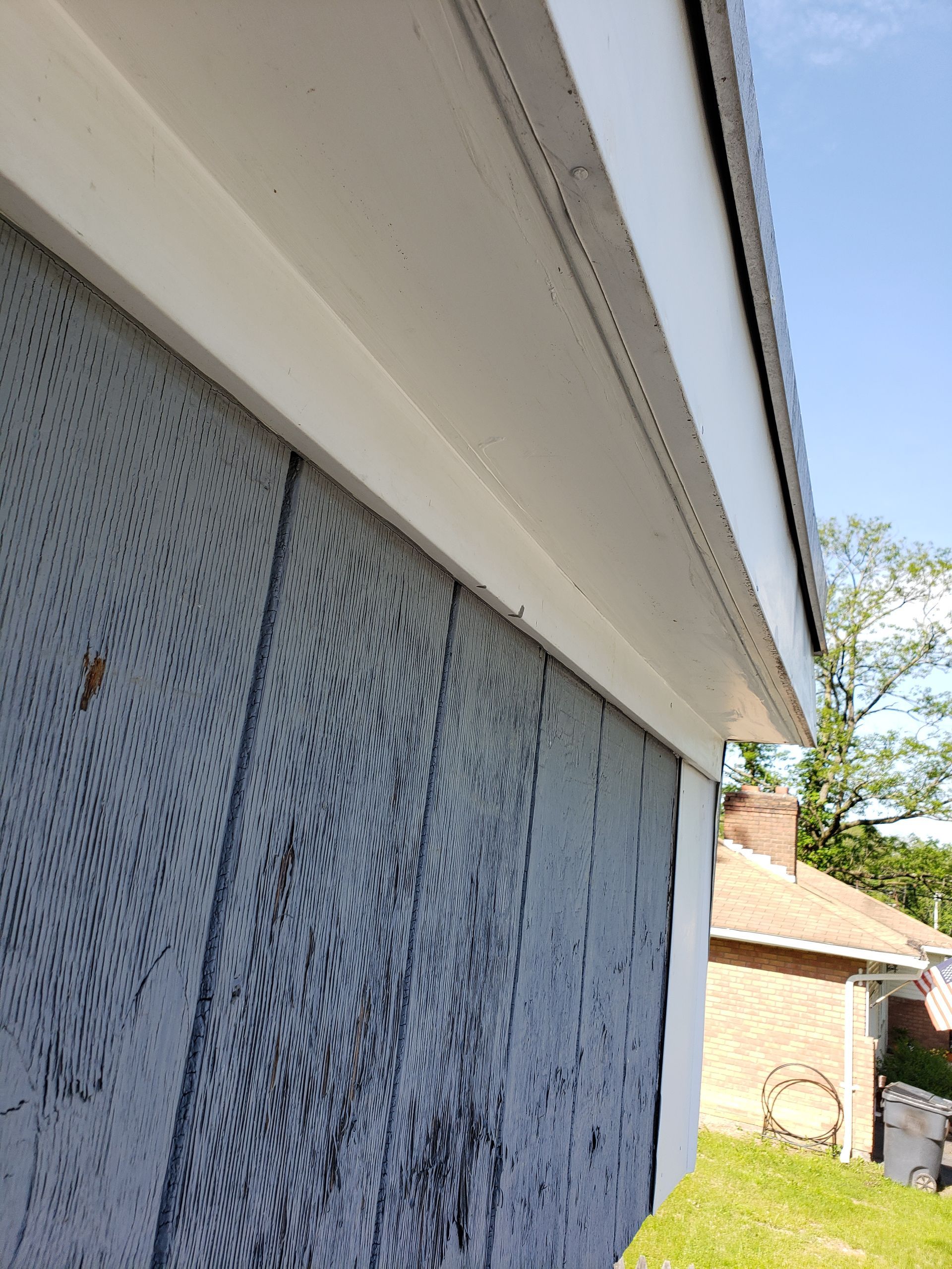 A close up of the side of a house with a white trim.