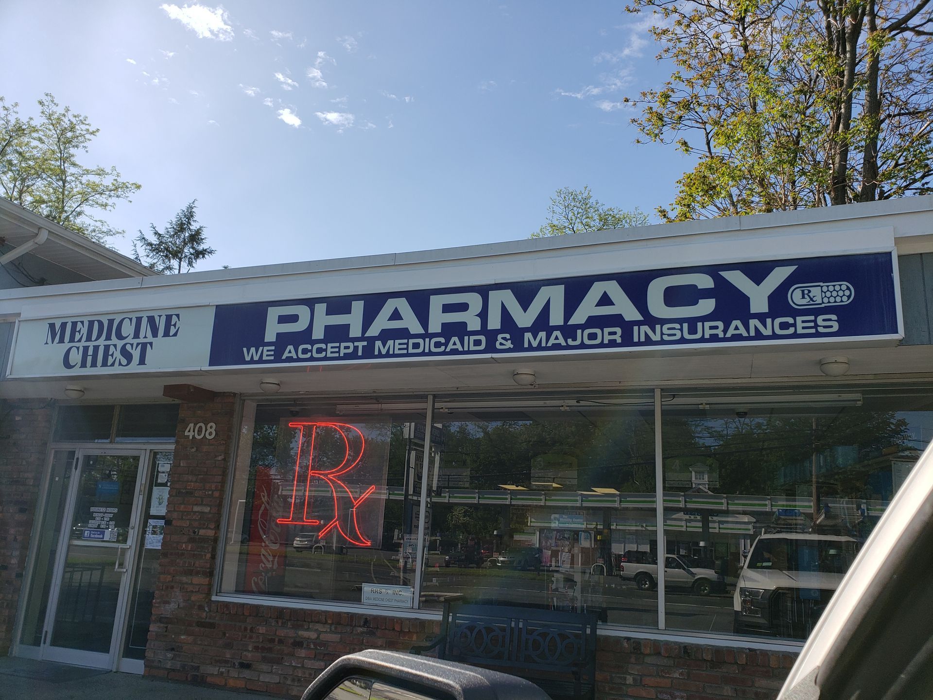 A pharmacy with a neon sign in front of it