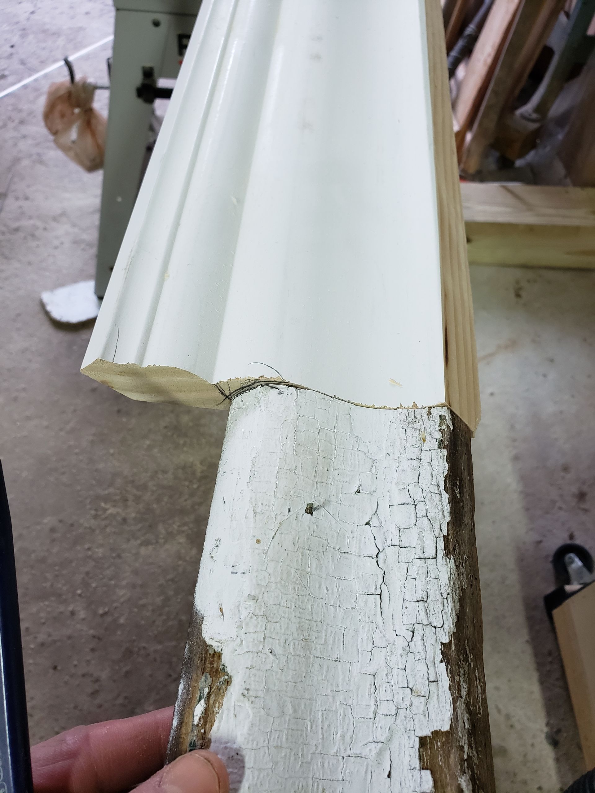 A person is holding a piece of white molding in their hand