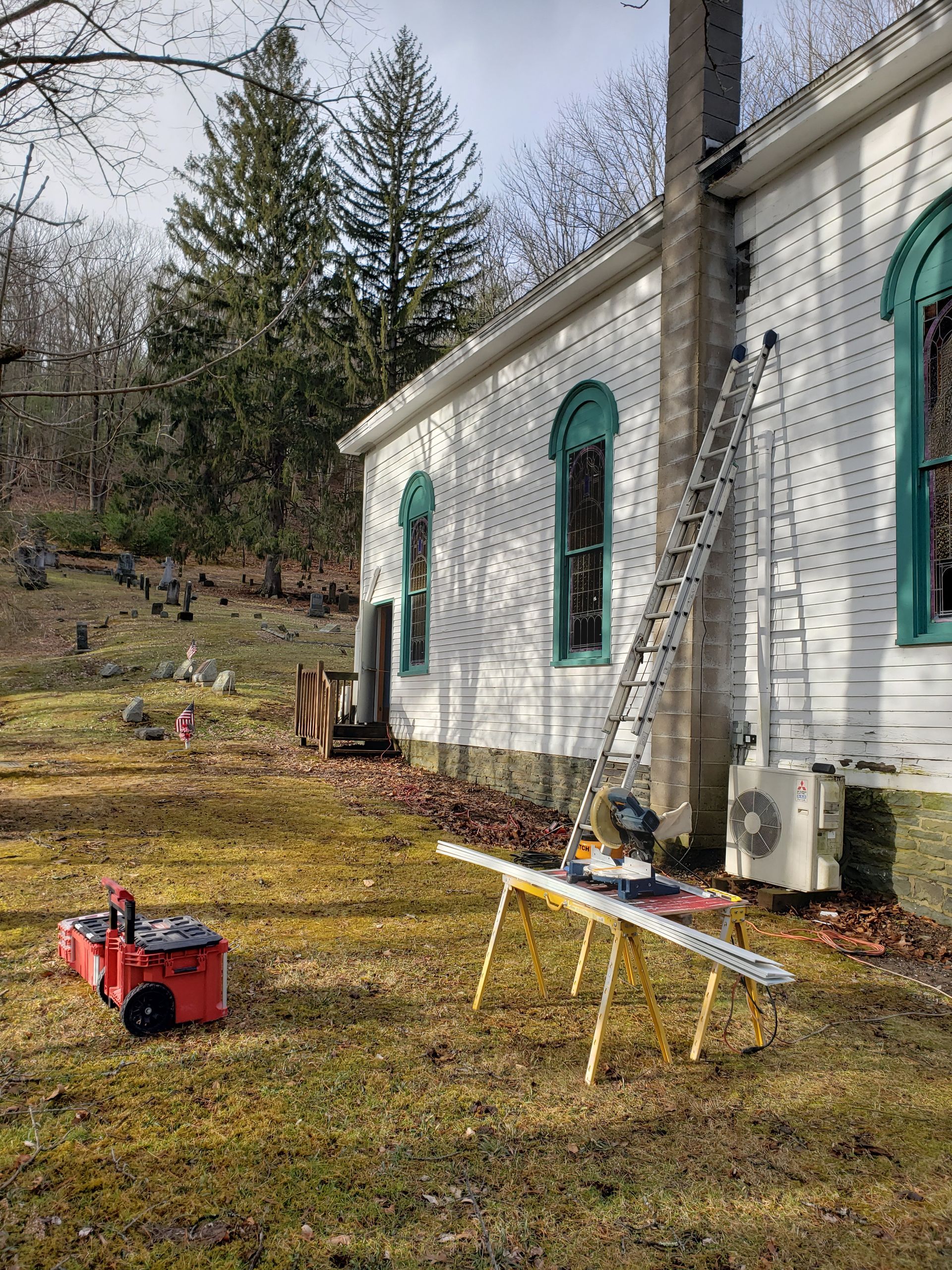 A ladder is sitting on a table in front of a white building.